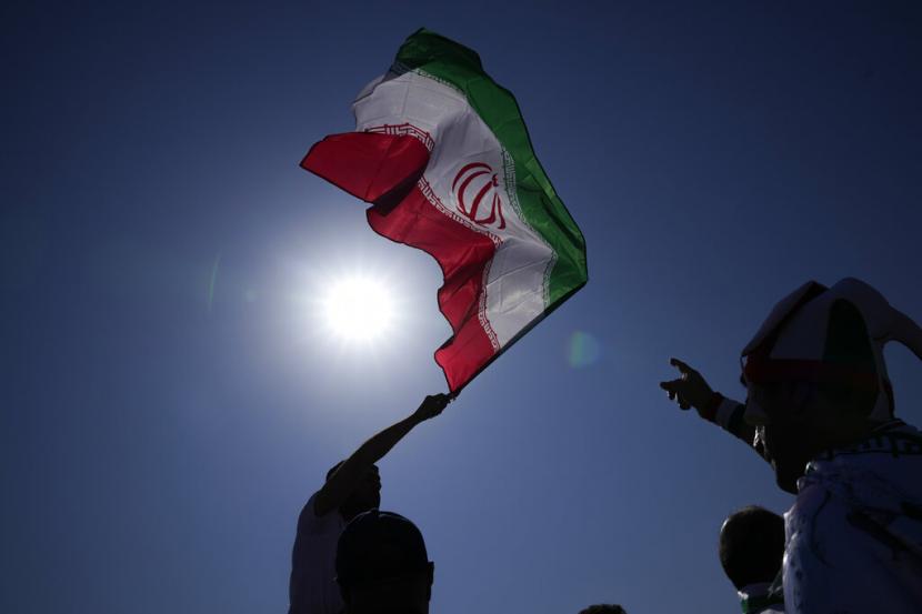 Seorang pendukung mengibarkan bendera Iran (ilustrasi). Iran kembali menangkap “kelompok teroris” yang diklaim terkait dengan Israel di negaranya. Mereka berjumlah 14 orang dan disebut hendak membunuh sejumlah individu.