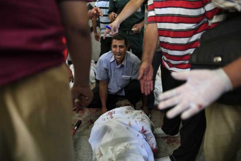 Seorang pendukung Presiden Mursi meratapi rekannya yang tewas diterjang peluru aparat keamanan Mesir dalam tragedi berdarah di Nasr City, Kairo, Sabtu (27/7).