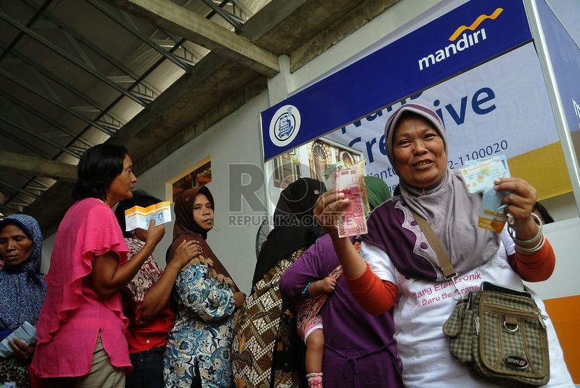  Sejumlah penerima bantuan sosial melakukan penarikan uang melalui agen Layanan Keuangan Digital (LKD) saat uji coba penyaluran dana bantuan Program Keluarga Harapan (PKH) melalui uang elektronik di Jakarta, Rabu (8/10).   (Republika/Prayogi)