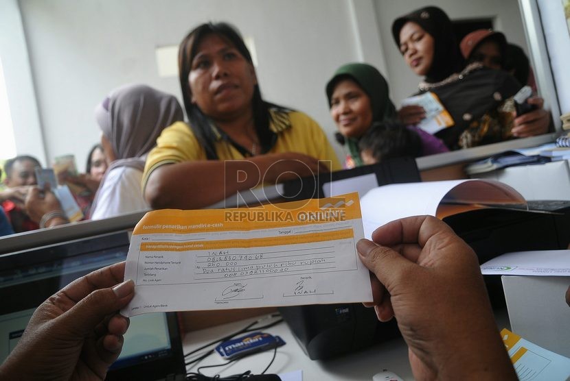  Seorang penerima bantuan sosial melakukan penarikan uang melalui agen Layanan Keuangan Digital (LKD) saat uji coba penyaluran dana bantuan Program Keluarga Harapan (PKH) melalui uang elektronik di Jakarta, Rabu (8/10).   (Republika/Prayogi)