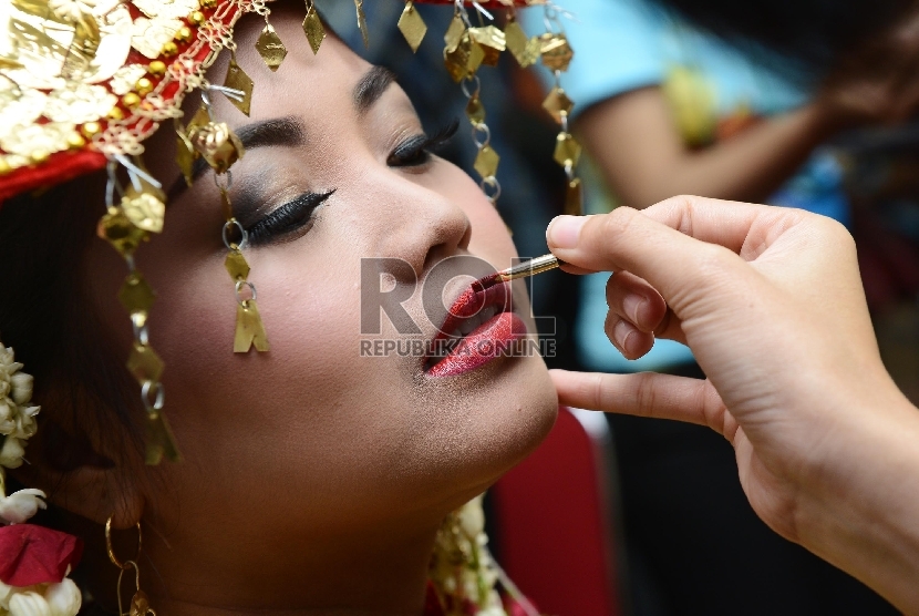  Seorang pengantin wanita dirias saat melaksanakan pernikahan massal yang diadakan di Istora Senayan, Jakarta Selatan, Rabu (28/1). (Republika/Raisan Al Farisi)