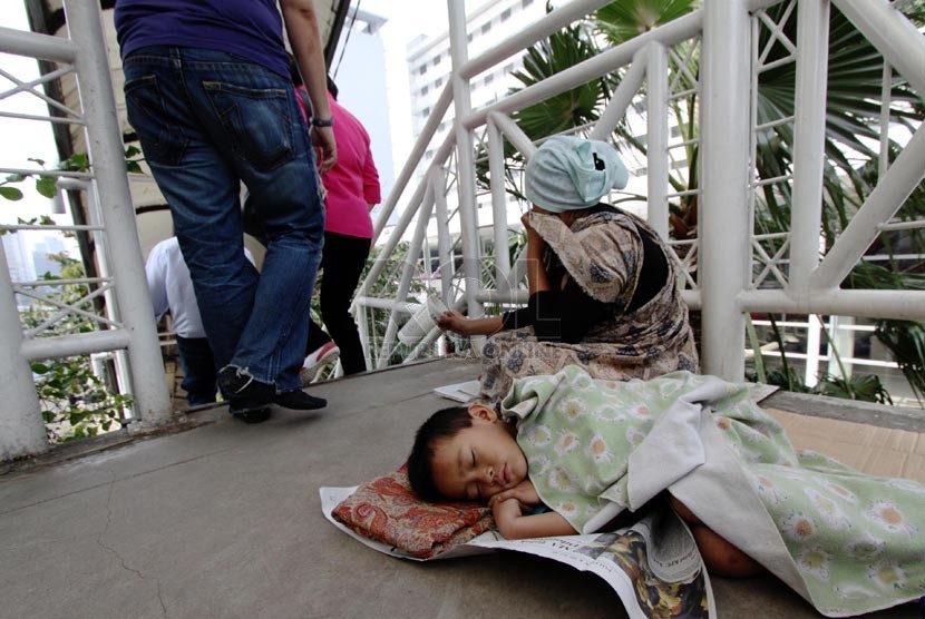  Seorang pengemis beraksi meminta sumbangan dari para pejalan kaki di Jembatan Penyeberangan Orang (JPO) Sarinah, Jakarta Pusat, Rabu (12/3). (Republika/Yasin Habibi)