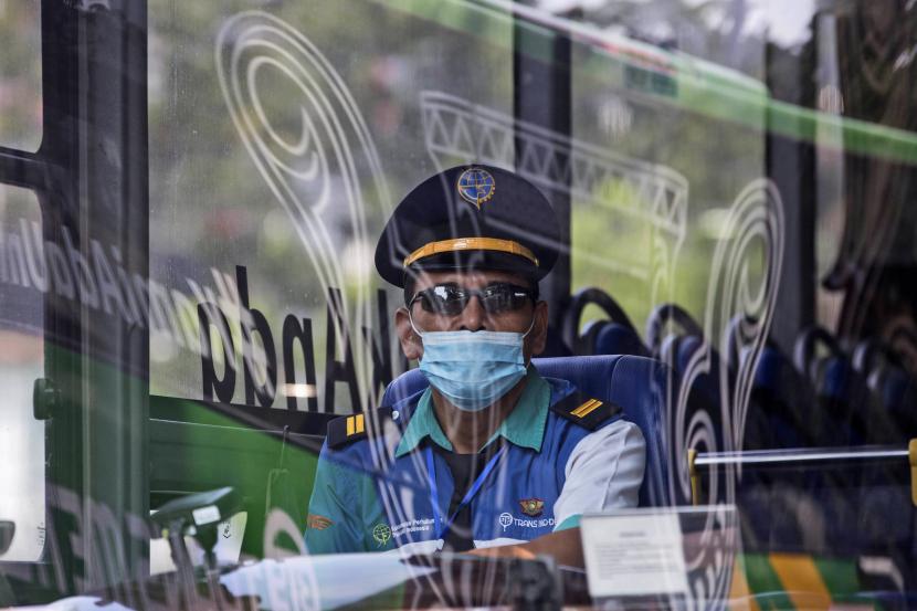 Seorang pengemudi bus yang mengenakan masker untuk mencegah penyebaran wabah COVID-19 menunggu penumpang di terminal bus di Medan, Sumatera Utara, Sabtu, 29 Januari 2022. 