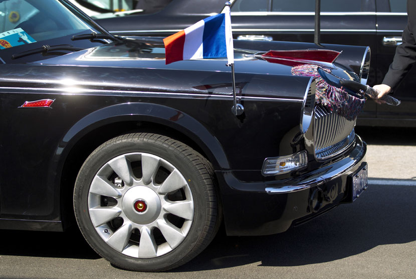  Seorang pengemudi mengelap mobil limusin mewah buatan Cina Hongqi, yang akan digunakan untuk menyambut kunjungan Presiden Perancis di Bandara Internasional Beijing,Cina, Kamis (25/4).   (AP/Andy Wong)