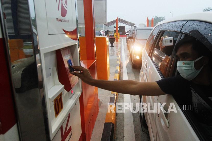 Seorang pengendara mobil menggunakan kartu E-Toll untuk memasuki Pintu Tol Dumai di Dumai, Riau, Jumat (25/9). Jalan Tol Trans Sumatra berpotensi membangun kantong ekonomi baru di tiap koridornya.
