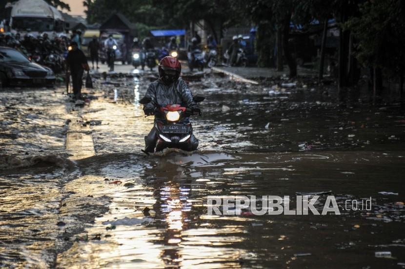 Seorang pengendara motor menerjang banjir di kawasan Gedebage, Bandung, Jawa Barat, ilustrasi. 