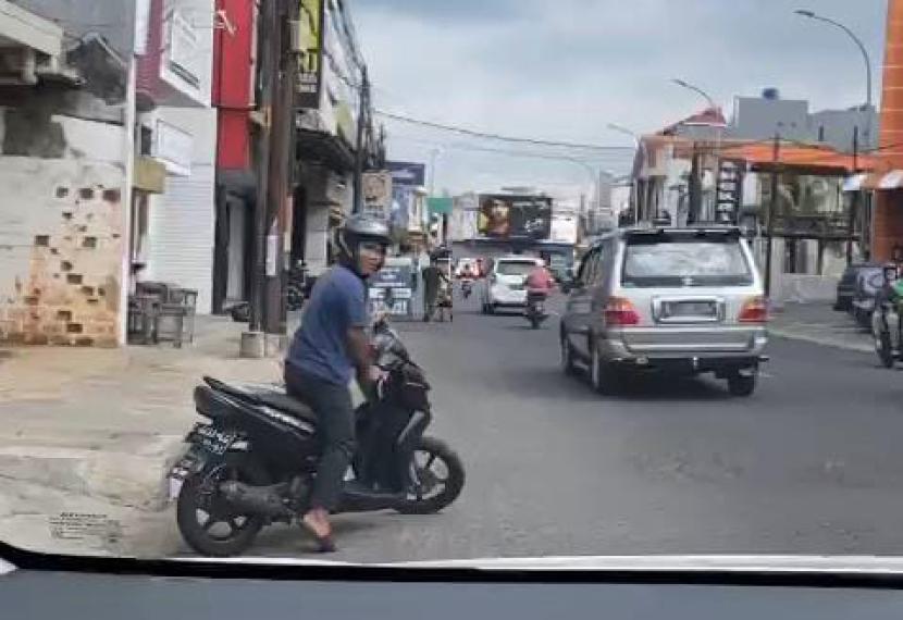Seorang pengendara sepeda motor mencoba menghentikan pengemudi mobil di wilayah Kota Tasikmalaya. 