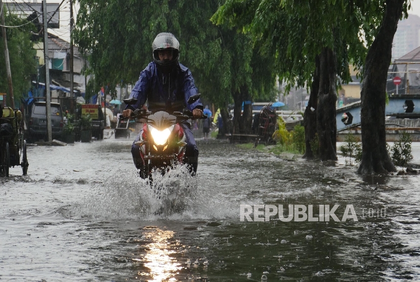 Seorang pengendara sepeda motor, menerobos genangan air di Jl Sunter Kemayoran Jakarta, yang digenangi air hujan air kali Item yang mulai tumpah ke jalan, Selasa (21/2). 