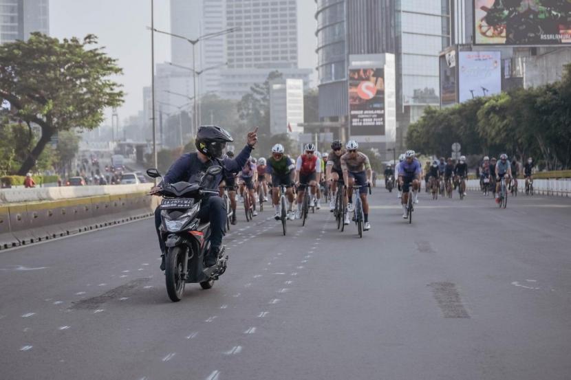 Seorang pengendara sepeda motor mengacungkan jari tengah ke rombongan pesepeda di Jalan Jenderal Sudirman, Jakarta Pusat. 