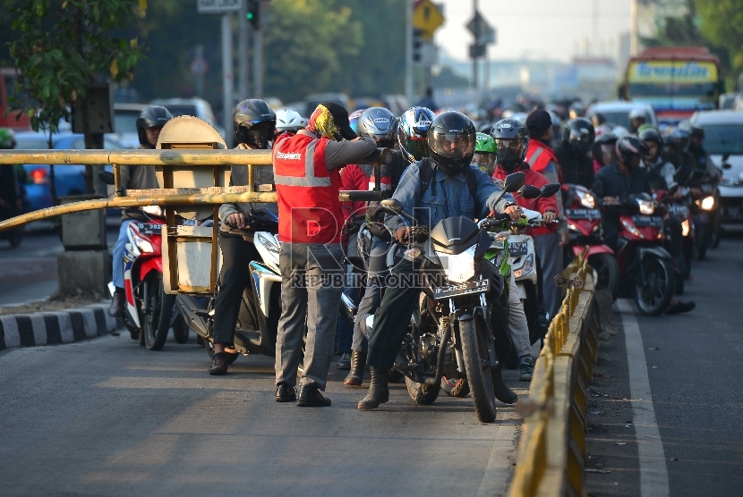 Seorang pengendara sepeda motor ngotot memasuki jalur busway yang ditutup oleh petugas di jalur TransJakarta di kawasan Mampang Prapatan, Jakarta Selatan, Kamis (4/9).