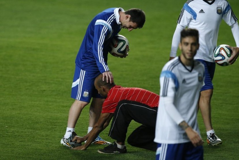 Seorang penggemar membersihkan sepatu Lionel Messi