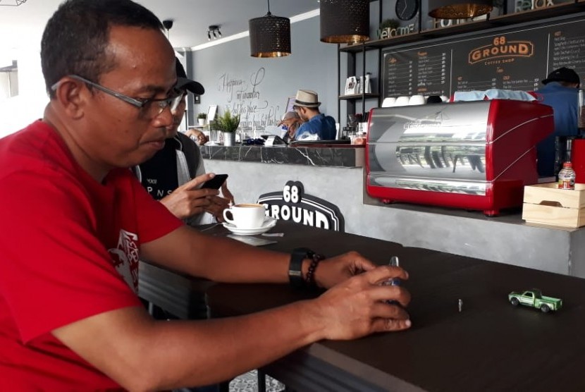 Seorang penggiat fotografi miniatur tengah mengambil gambar obyek kecil di salah satu cafe di Kota Sukabumi Ahad (3/2). Keberadaan miniatur fotografi ini selain hobi tapi bisa menghasilkan pendapatan.