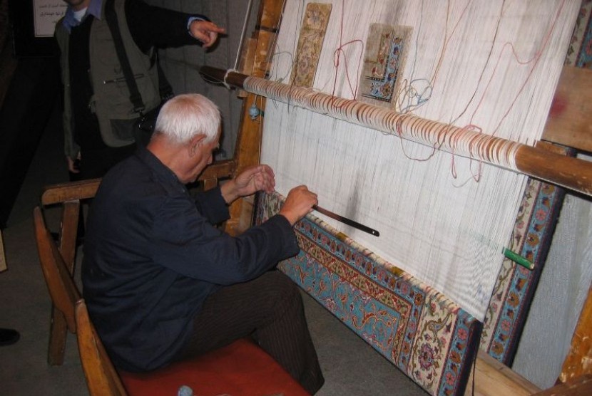 Proyek Restorasi Karpet Bersejarah Iran Rampung. Seorang pengrajin Iran sedang membuat karpet.