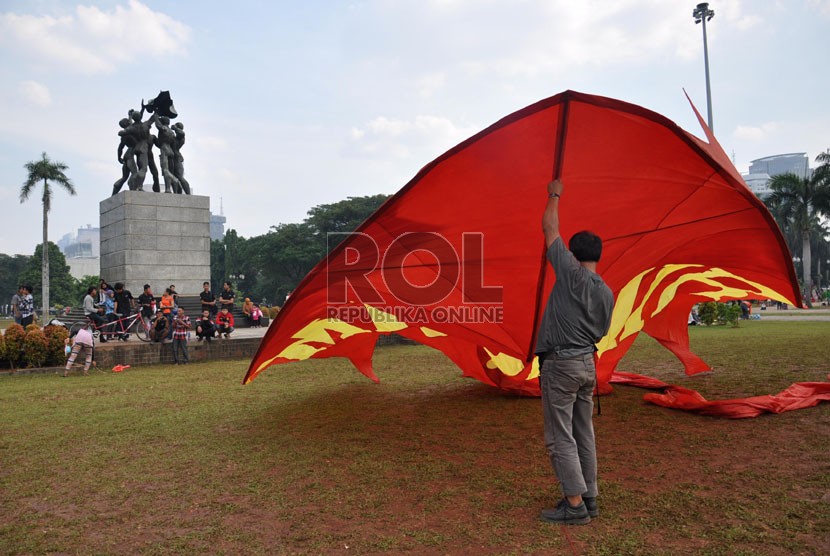  Seorang pengrajin layang-layang, Agus Pirano (50) mempersiapkan layangannya untuk diterbangkan di kawasan silang Monas, Jakarta, Ahad (9/6).  (Republika/Rakhmawaty La'lang)