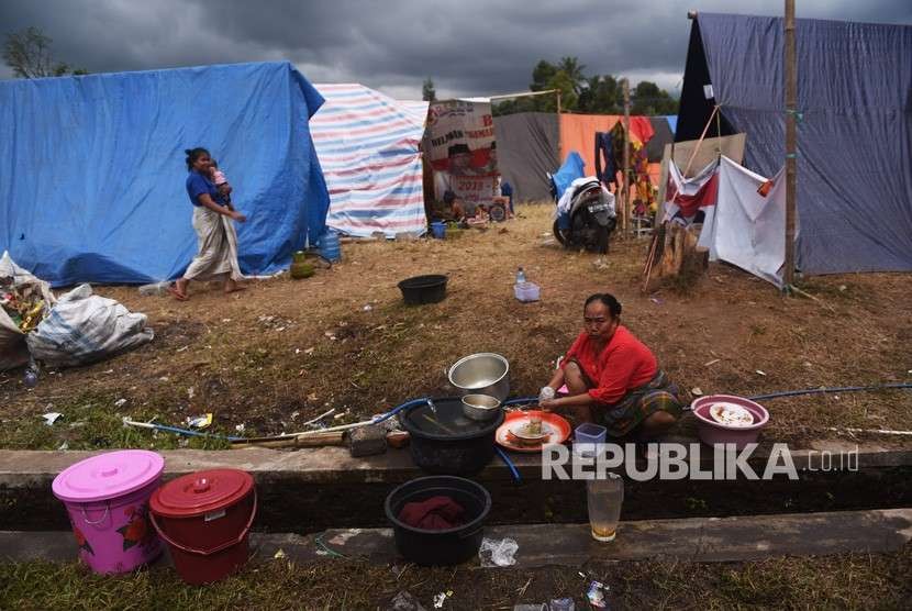 Seorang pengungsi korban gempa bumi mencuci pakaian mengunakan air dari parit di dekat tempat pengungsian di Desa Santong, Kayangan, Lombok Utara, NTB, Sabtu (11/8)