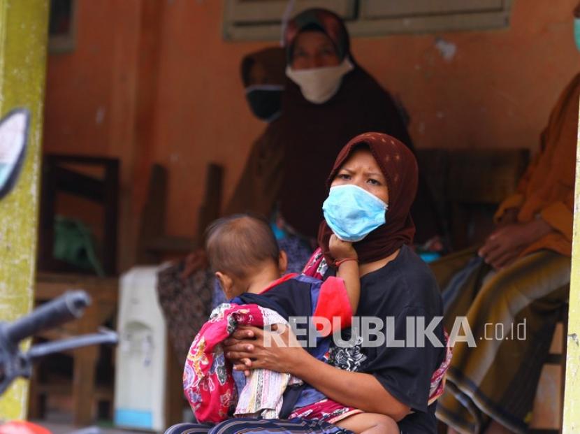 Seorang warga menggendong anaknya di lokasi pengungsian letusan Gunung Semeru di SDN Supiturang 4, Pronojiwo, Lumajang, Jawa Timur, Senin (6/12/2021). IDAI memberikan panduan bagi orang tua terkait perawatan-perlindungan anak saat gunung meletus.