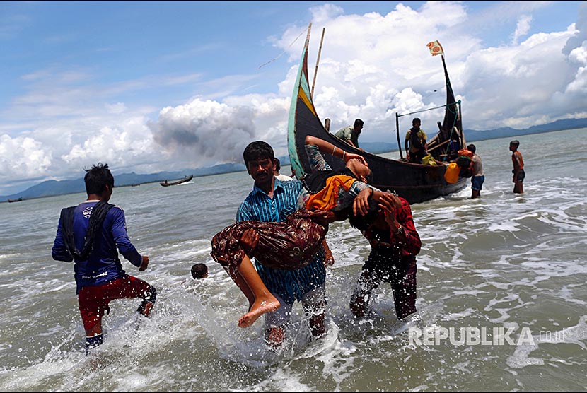 A Rohingya refugee was carried into the waters of the Bay of Bengal while smoke billowed from a distance of Myanmar, in Shah Porir Dwip, Bangladesh, Tuesday (September 11).