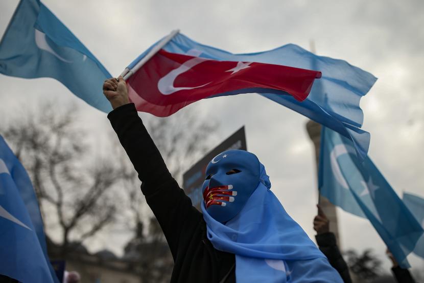 Senat AS Loloskan RUU Pencegahan Kerja Paksa Uighur. Seorang pengunjuk rasa dari komunitas Uighur yang tinggal di Turki mengibarkan bendera Turki saat protes terhadap kunjungan Menteri Luar Negeri China Wang Yi ke Turki, di Istanbul, Kamis, 25 Maret 2021. 