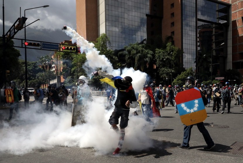 Seorang pengunjuk rasa melemparkan bom molotov saat berunjuk rasa di Kota Karakas, Venezuela.