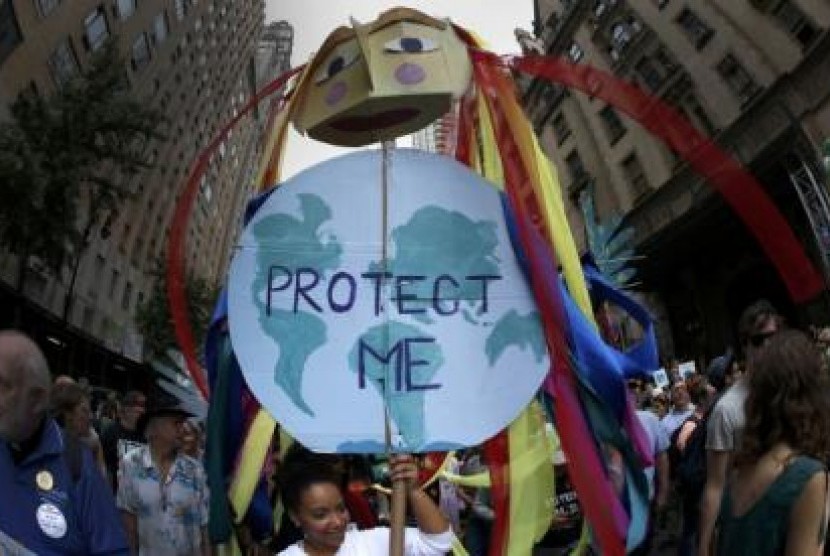 Seorang pengunjuk rasa membawa poster berbentuk Mother Earth sebagai bentuk unjuk rasa atas perubahan iklim di New York, Ahad (21/9).