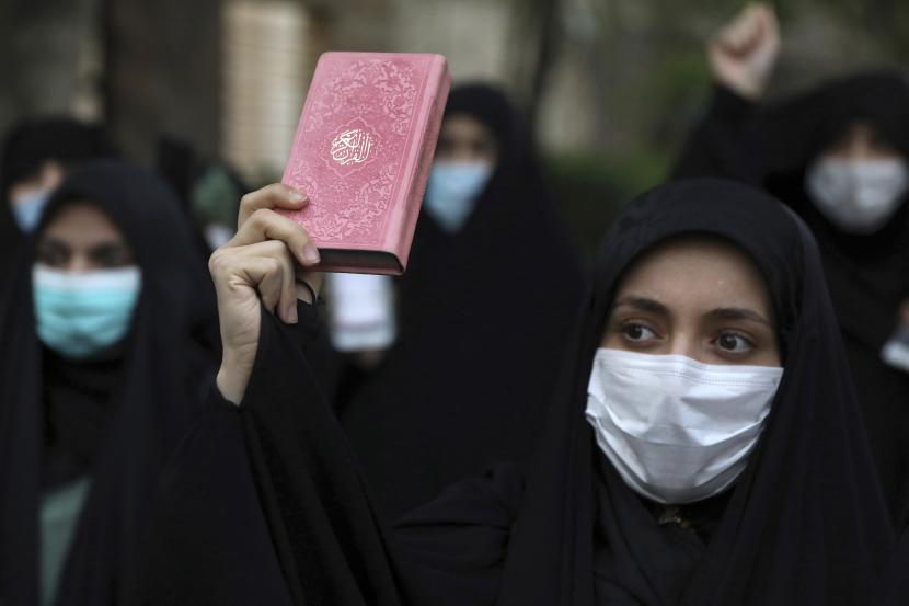 Seorang pengunjuk rasa memegang salinan Alquran, kitab suci umat Islam, selama demonstrasi mengutuk rencana pembakaran Alquran oleh kelompok sayap kanan di Swedia, di depan Kedutaan Besar Swedia di Teheran, Iran, Senin, 18 April 2022.