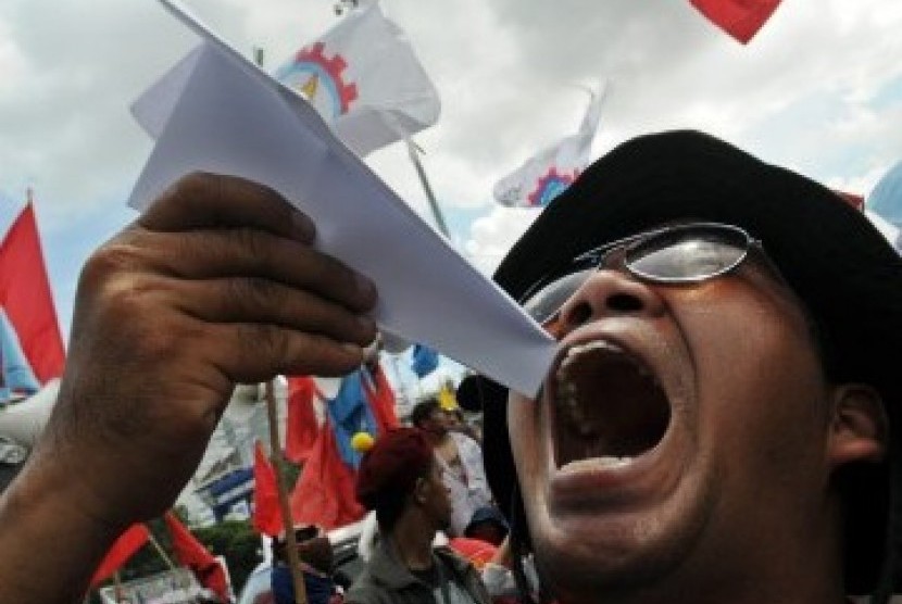 Seorang pengunjuk rasa menyindir pemerintah dengan menerbangkan pesawat kertas saat sekitar 10.000 pengunjuk rasa dari melakukan aksi menolak kenaikan harga bahan bakar minyak (BBM) di Istana Negara, Jakarta, Rabu (21/3). (Republika/Aditya Pradana Putra)