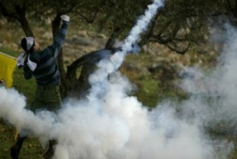 Seorang pengunjuk rasa Palestina melempar balik kaleng gas air mata dalam demonstrasi menentang tembok pembatas di desa Bilin, dekat Ramalah, Tepi Barat, Jumat (31/12/2010)