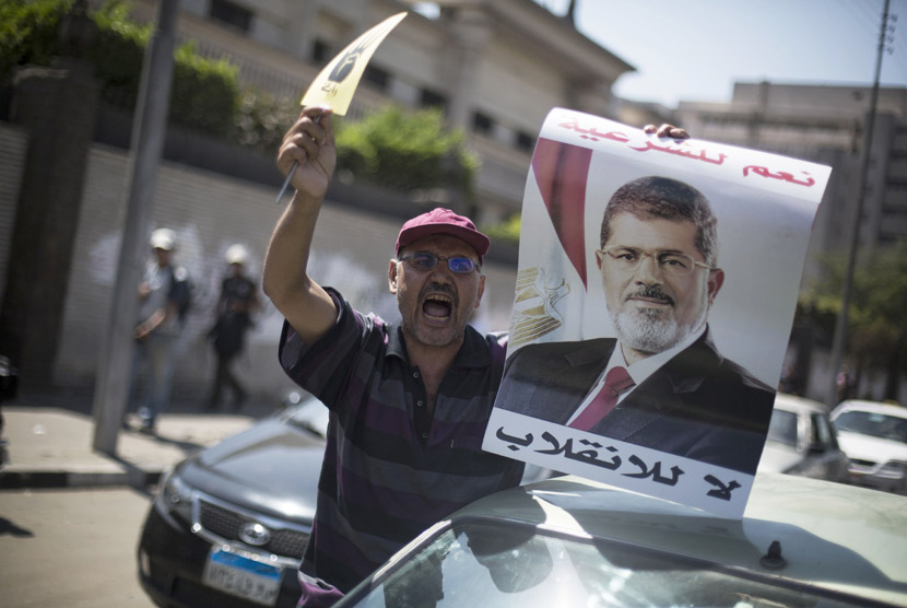  Seorang pengunjuk rasa pendukung Presiden Muhammad Mursi meneriakkan slogan  melawan militer Mesir dalam aksi unjuk rasa di dekat masjid Al-Nour di Kairo, Jumat (23/8).   (AP/Manu Brabo)