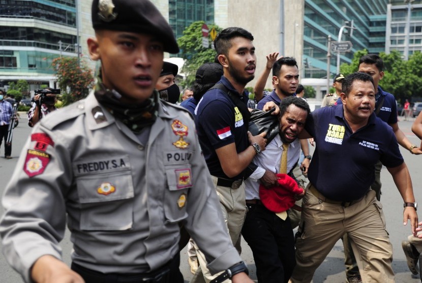 Seorang pengunjukrasa dari Aliansi Mahasiswa Papua diamankan polisi usai terlibat kericuhan ketika melakukan aksi di Kawasan Bundaran Hotel Indonesia, Jakarta, Selasa (1/12). 