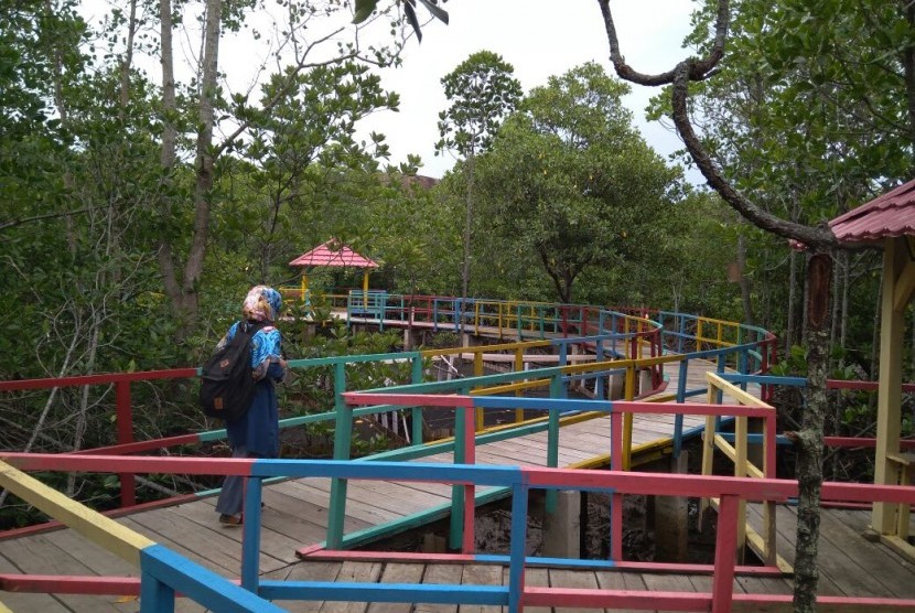 Seorang pengunjung berjalan di atas tracking mangrove di Desa Langge, Kabupaten Gorontalo Utara, Kamis (25/8). 