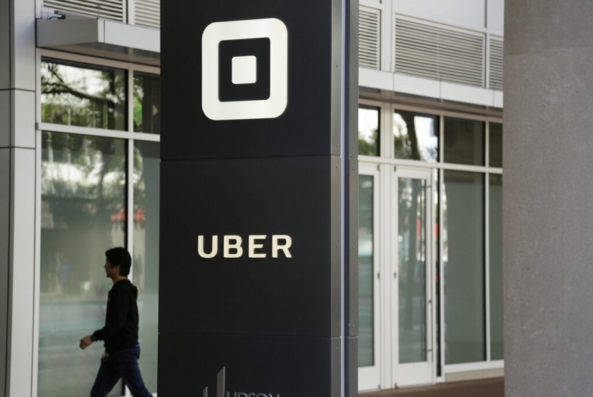 Seorang pengunjung berjalan di Kantor Uber di San Francisco. Uber mengumumkan rencana untuk go public