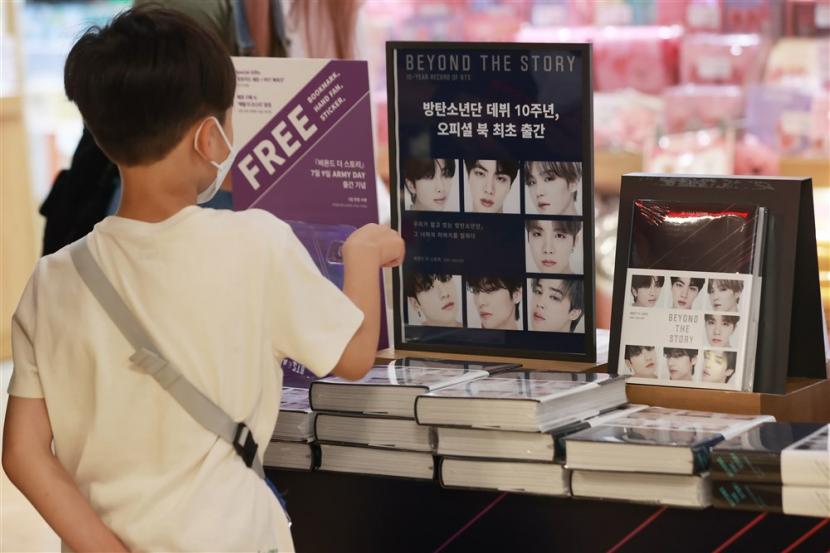 Seorang pengunjung Kyobo Book Store di Seoul, Korea Selatan mengamati buku Beyond the Story: 10-year Record of BTS yang dirilis 9 Juli 2023.