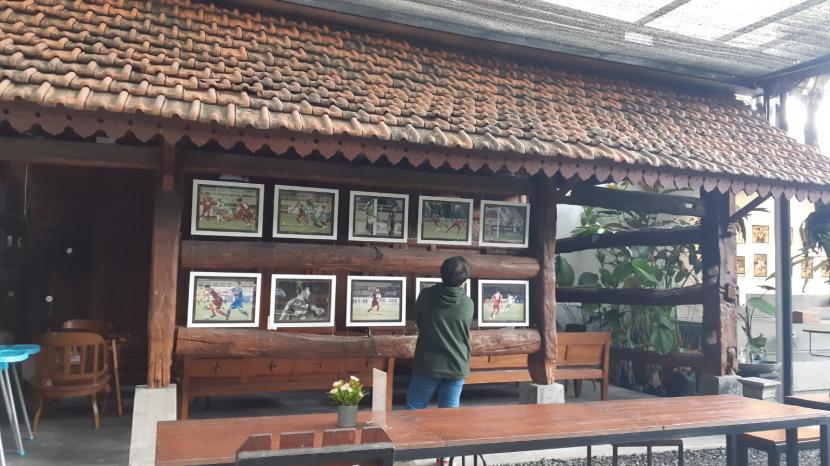 Seorang pengunjung melihat pameran foto perjalanan Persis dalam mengarungi Liga 2 2021 di Persis Store & Cafe, Manahan, Solo, Jawa Tangah, Jumat (28/1). Pameran foto itu merupakan rangkaian acara Pekan Sambernyawa Juara yang digelar pada 28 Januari-18 Februari mendatang. 