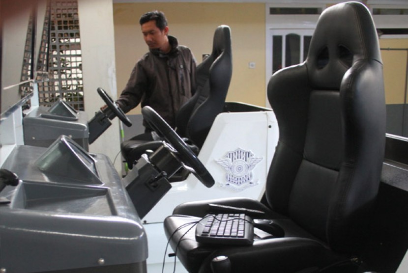 Seorang pengunjung melihat simulator mengemudi kendaraan roda empat yang belum difungsikan di Satuan Penyelenggara Administrasi SIM (Satpas), Malang, Jawa Timur, Kamis (2/8).