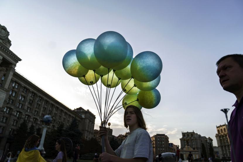 Seorang pengunjung membawa balon biru kuning serupa bendera Ukraina di Maidan Square di Kyiv, Ukraina, Selasa (23/8/2022). Washington akan mengumumkan paket bantuan baru untuk Ukraina senilai 3 miliar dolar AS. 