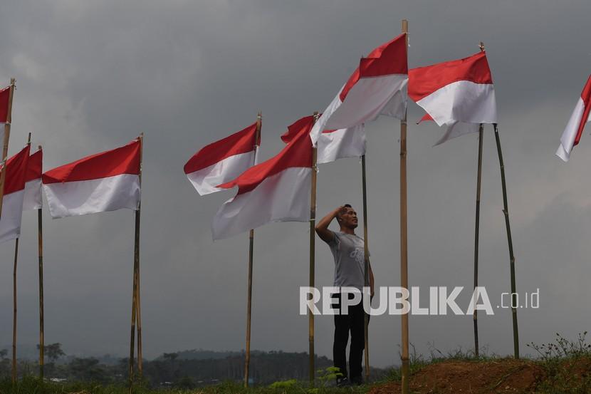 Seorang pengunjung memberi hormat ke bendera Merah Putih yang dipasang di Poetoek Suko, Trawas, Mojokerto, Jawa Timur, Ahad (16/8/2020). Pemasangan ribuan bendera Merah Putih di tempat wisata tersebut guna memeriahkan HUT Kemerdekaan ke-75 RI.