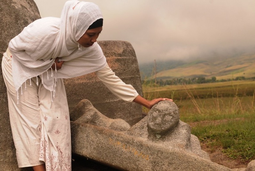 Seorang pengunjung memerhatikan salah satu ornamen penutup bejana raksasa (Kalampa) di situs megalith pokoke di Desa Besoa, Kec. Lore Tengah, Kab. Poso, Sulteng, Sabtu (4/6). Situs yang peninggalan zaman batu yang terdiri dari bejana raksasa dan patung bat