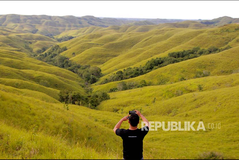 Seorang pengunjung mengabadikan panorama Bukit Wairinding di Kabupaten Sumba Timur, NTT (19/2). Bukit Wairinding merupakan salah satu lokasi wisata alam yang mejadi destinasi bagi wisatawan domestik dan mancanegara. 