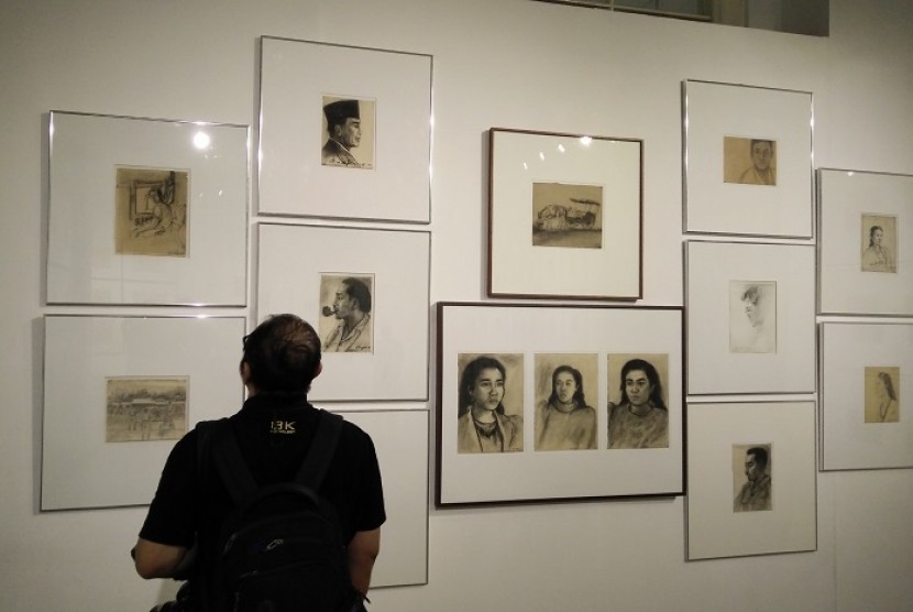 Seorang pengunjung mengamati lukisan Srihadi Soemarsono yang dipamerkan di Galeri Nasional Jakarta