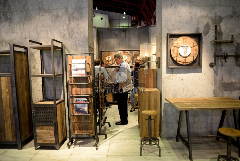 Seorang pengunjung mengamati produk furniture dalam sebuah pameran. ilustrasi