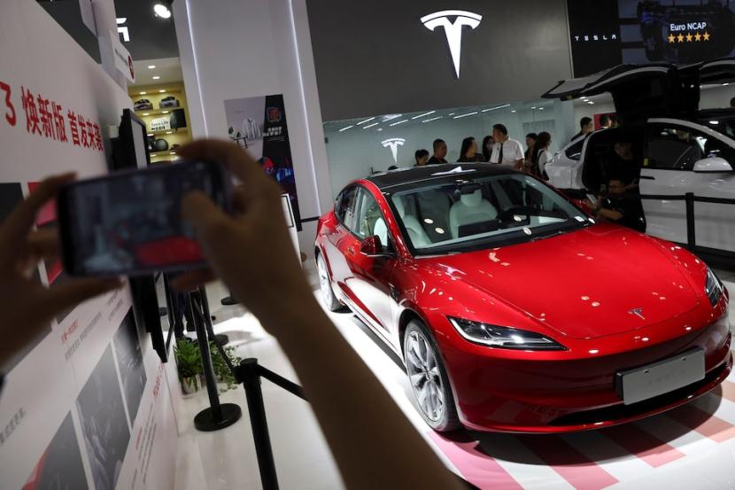 Seorang pengunjung mengambil gambar sedan Model 3 Tesla yang dipamerkan di Pameran Perdagangan Jasa Internasional China (CIFTIS) di Beijing, China, 2 September 2023. 