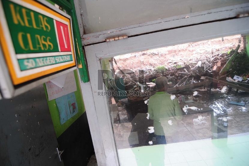 Seorang penjaga membenahi ruang kelas yang rusak di SD Negeri Suka Asih komplek Suka Asih, Kota Bandung, Rabu (4/3).  (foto : Septianjar Muharam)