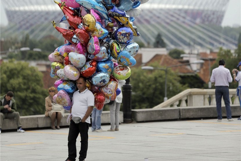 Seorang penjual balon berjualan di Zamkowy Square dekat Stadion Nasional, Warsawa, Polandia, Kamis (7/6). 