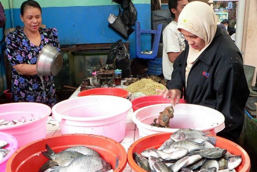 Seorang penjual ikan (kiri) melayani seorang pembeli ikan di pasar Temanggung, Jateng,