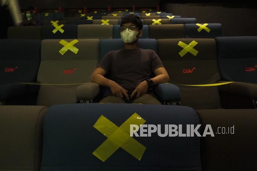 Seorang penonton duduk dengan menjaga jarak sesuai dengan protokol kesehatan di dalam studio bioskop. Seiring penurunan level PPKM di Semarang, sejumlah bioskop di Ibu Kota Jawa Tengah tersebut mengajukan izin operasional.