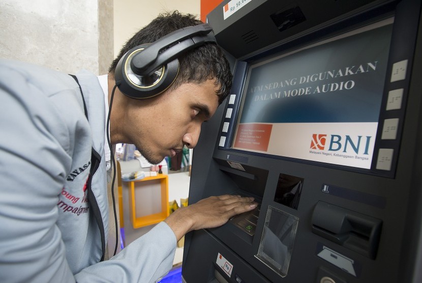 Seorang penyandang disabilitas mencoba bertransaksi di mesin ATM Bank BNI yang dilengkapi fasilitas bagi penyandang disabilitas. ilustrasi