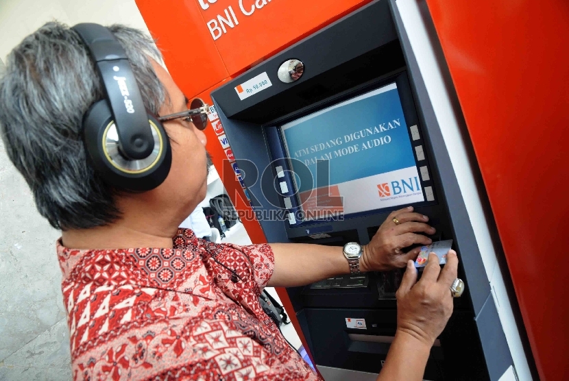 Seorang penyandang disabilitas mencoba bertransaksi di mesin ATM Bank BNI yang dilengkapi fasilitas bagi penyandang disabilitas di Gedung Kementerian Sosial, Jakarta, (ilustrasi).