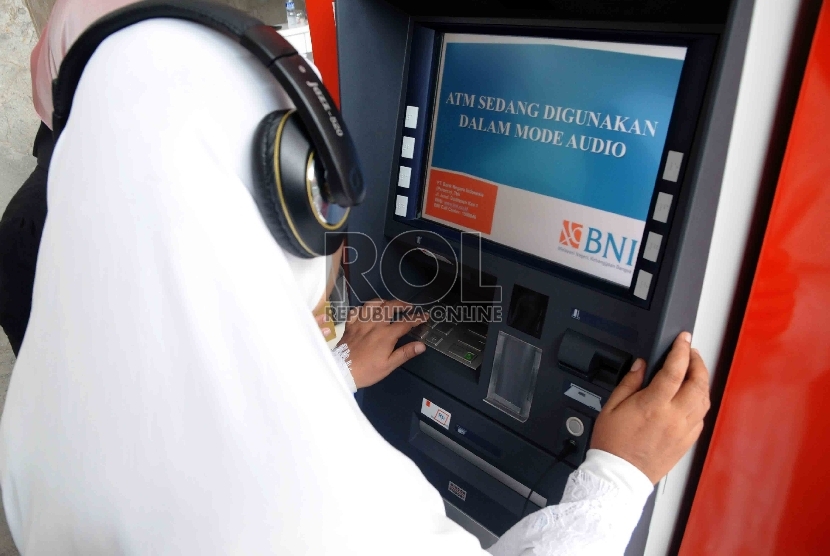 Seorang penyandang disabilitas mencoba bertransaksi di mesin ATM Bank BNI yang dilengkapi fasilitas bagi penyandang disabilitas di Gedung Kementerian Sosial, Jakarta, Selasa (1/12).