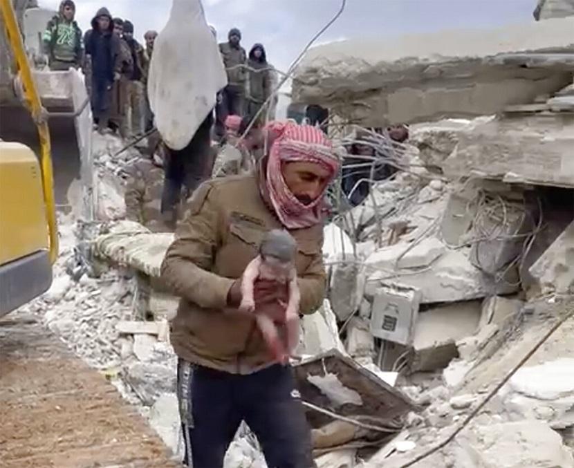 Seorang penyelamat membawa bayi perempuan setelah menariknya dari puing-puing akibat gempa bumi yang melanda Suriah dan Turki di kota Jinderis, Suriah, Selasa, 7 Februari 2023. 