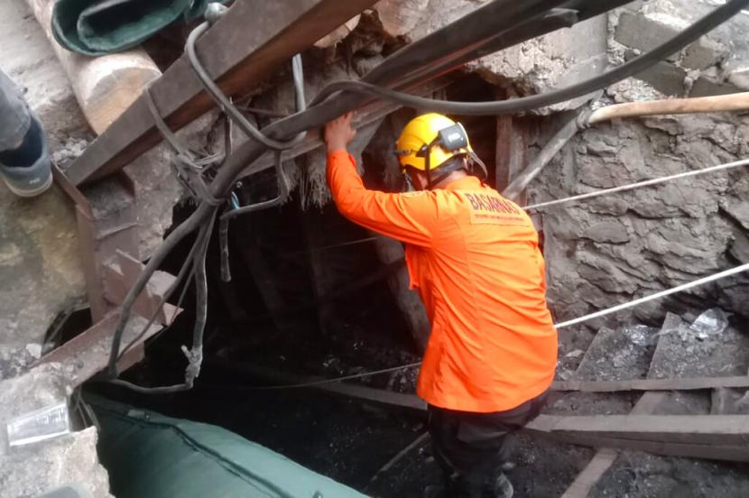  Seorang penyelamat menunggu di pintu masuk tambang batu bara saat mencari korban setelah ledakan di Sawahlunto, Sumatera Barat, Jumat, 9 Desember 2022. Ledakan yang disebabkan oleh gas berbahaya termasuk metana itu menewaskan sejumlah penambang. 